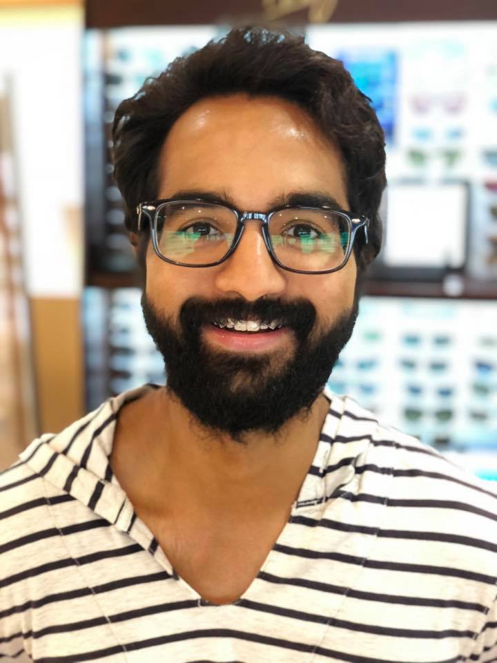 The image shows a smiling man with glasses and a beard.