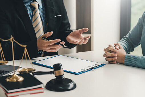 Lawyer discussing a case with a client at a desk.